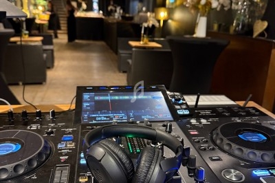 Table de mixage avec casque audio posé dessus, dans un espace intérieur élégant et faiblement éclairé.