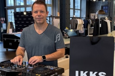 Un homme mixe de la musique sur une table de mixage dans un magasin de vêtements modernes.