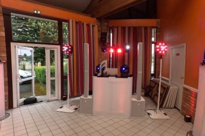 Installation de matériel de sonorisation et d'éclairage avec projecteurs colorés dans une salle aux murs orange.