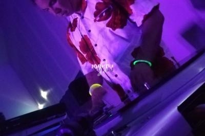 Un DJ mixant de la musique sur une table de mixage dans une ambiance lumineuse violette.