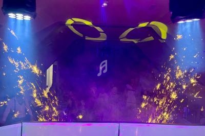 Effets lumineux et étincelles dans une ambiance de fête avec éclairage coloré et fumée en arrière-plan.