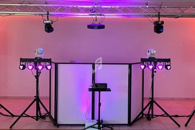 Installation d'équipements d'éclairage et de projection pour un événement, avec projecteurs et lumières colorées.