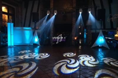 Jeu de lumières colorées projetées sur un sol carrelé dans une salle avec équipement de sonorisation.