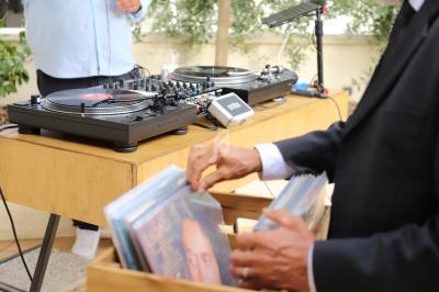 Un homme feuillette des disques vinyles près d'une table équipée de platines et d'une console de mixage.