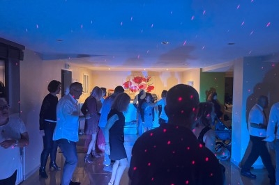 Des personnes dansent dans une salle éclairée par des lumières colorées et des spots lumineux.