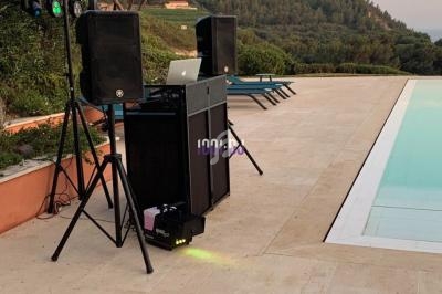 Équipement de sonorisation installé près d'une piscine avec vue sur des collines et un ciel dégagé.