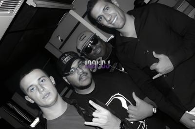 Quatre hommes posant ensemble dans un environnement intérieur, certains faisant des gestes de la main.