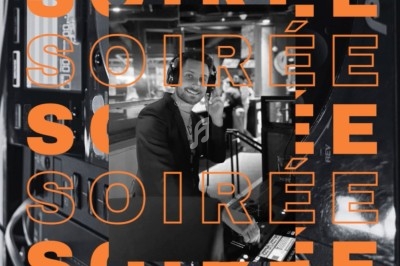 Un homme en costume souriant dans un environnement sombre, entouré du mot ’SOIRÉE’ répété en orange.