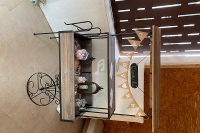Chariot en bois et métal décoré avec des bonbonnières, un miroir et une guirlande ’Candy Bar’, dans un espace intérieur.