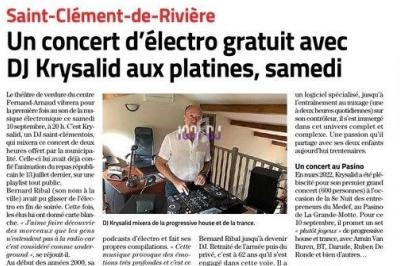 Un homme debout derrière des platines de DJ dans une pièce lumineuse avec des équipements audio visibles.