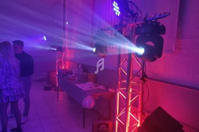 Éclairage de scène avec projecteurs LED colorés et table en arrière-plan dans une salle de réception.
