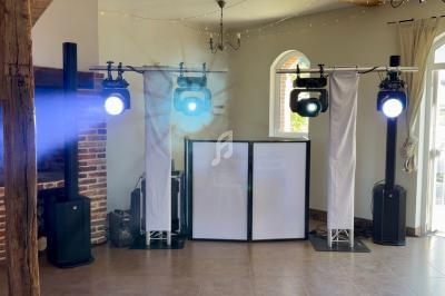 Installation de matériel d'éclairage et de sonorisation dans une salle avec murs en briques et fenêtres cintrées.