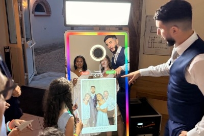 Un groupe de personnes utilise un miroir photobooth interactif lors d'un événement en intérieur.