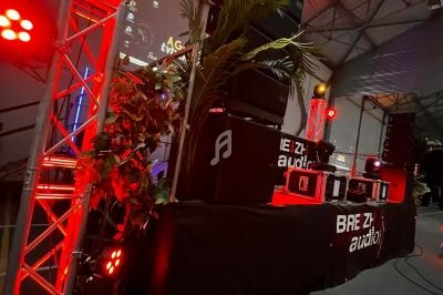 Scène intérieure avec éclairage rouge, équipements audio professionnels et structure métallique dans un espace industriel.