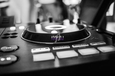 Table de mixage en gros plan avec des boutons et un plateau tournant, en noir et blanc.