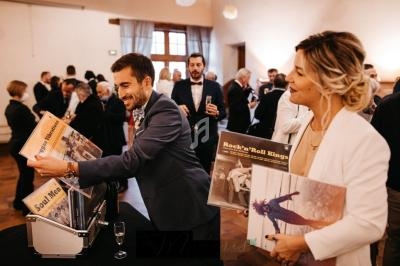Un homme et une femme regardent des vinyles dans une salle remplie de personnes lors d'un événement.