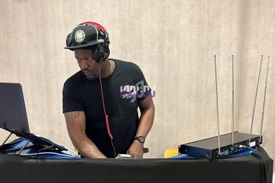 Un homme portant un casque audio mixe de la musique sur un ordinateur portable, avec un équipement audio à ses côtés.