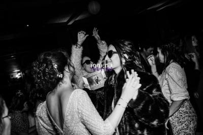 Des personnes dansent et s'amusent dans une ambiance festive, capturées en noir et blanc.