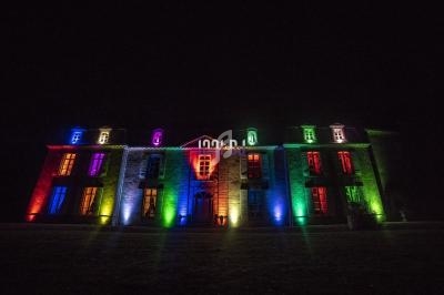 Façade d'un bâtiment illuminée par des lumières colorées dans un environnement nocturne.
