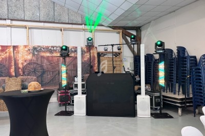 Installation de matériel de sonorisation et d'éclairage dans une salle décorée avec des éléments rustiques.