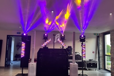Installation de matériel d'éclairage et de sonorisation avec projecteurs colorés dans une salle intérieure.
