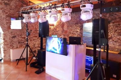 Équipement de sonorisation et éclairage installé dans une salle en pierre pour un événement.