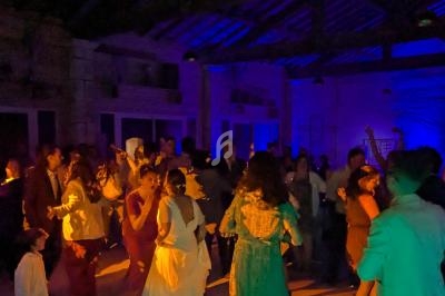 Groupe de personnes dansant dans une salle faiblement éclairée avec des lumières colorées.