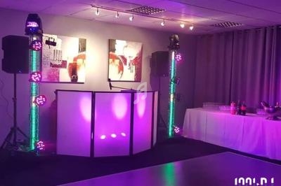 Installation de matériel de son et lumière avec une piste de danse éclairée dans une salle décorée.