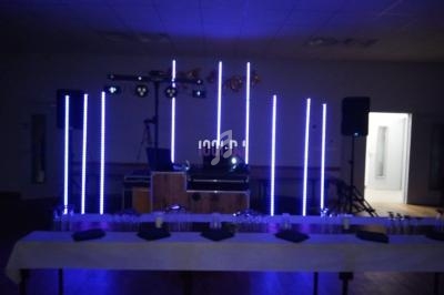 Installation de matériel de sonorisation et d'éclairage avec des lumières LED dans une salle sombre.