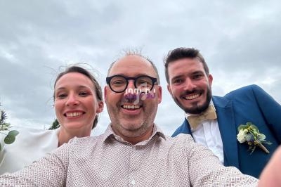 Trois personnes souriantes posant pour un selfie en extérieur sous un ciel nuageux.