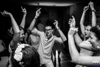 Des personnes dansent et s'amusent dans une ambiance festive, capturées en noir et blanc.