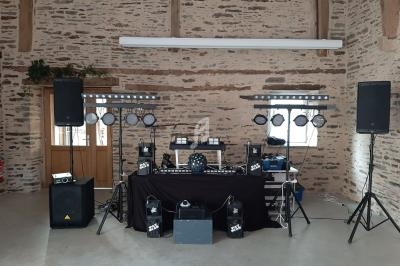 Installation de matériel de sonorisation et d'éclairage dans une salle en pierre avec des murs apparents.