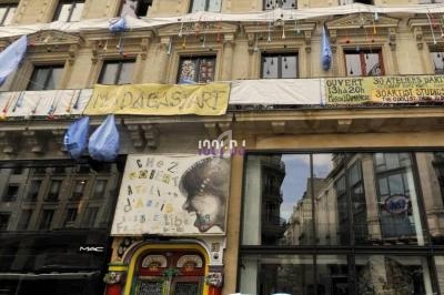 Façade d'un immeuble décoré avec des œuvres d'art, des banderoles et des inscriptions, abritant des ateliers artistiques.