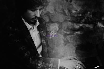 Un DJ concentré mixe de la musique sur une table de mixage dans une ambiance sombre et tamisée.