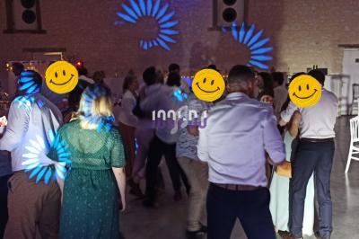 Groupe de personnes dansant dans une salle éclairée par des lumières colorées, ambiance festive en soirée.