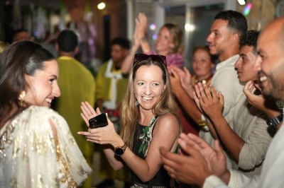 Des personnes souriantes applaudissent et dansent dans une ambiance festive et conviviale.