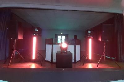 Installation de matériel de sonorisation et d'éclairage sur une scène, avec projecteurs et haut-parleurs.