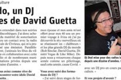 Un homme portant un casque audio sourit et fait un signe de pouce levé, avec un article de journal en arrière-plan.