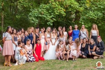 Un groupe de femmes posant ensemble dans un parc, entourées d'arbres et de verdure.
