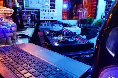 Équipement de DJ avec platines et console de mixage sur une table dans un environnement de bar ou restaurant.