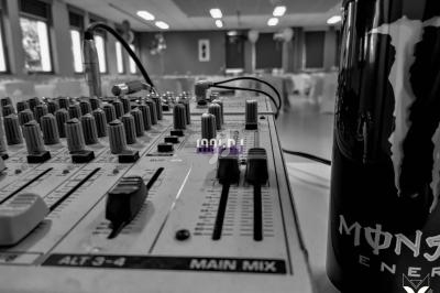 Table de mixage avec curseurs et boutons en gros plan, posée sur une table dans une salle lumineuse, avec une canette à…