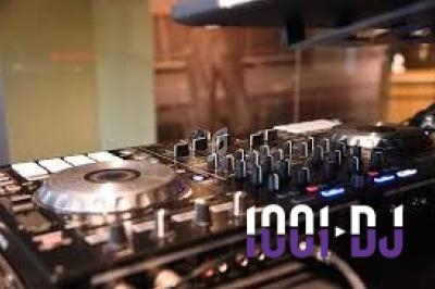 Table de mixage DJ avec boutons, platines et commandes, posée sur une surface dans un environnement intérieur.