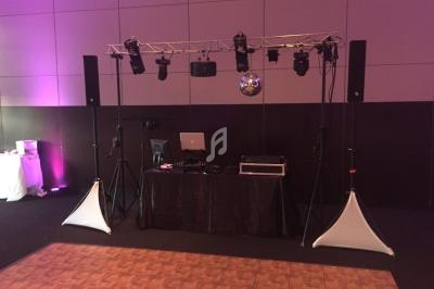 Installation de matériel de sonorisation et éclairage pour un événement, avec une piste de danse au premier plan.