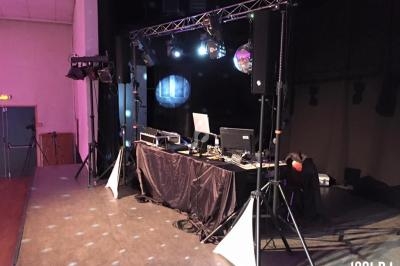 Équipement de sonorisation et éclairage installé sur une scène, avec une table de mixage et des projecteurs.