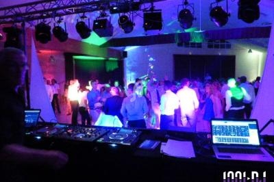 Vue d'une soirée dansante avec une piste éclairée de lumières colorées, vue depuis la table du DJ.