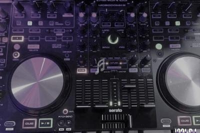 Table de mixage DJ Denon avec platines, boutons et curseurs éclairés, utilisée pour le mixage audio.