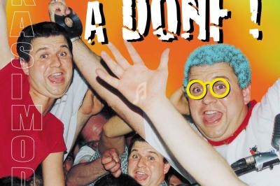 Des personnes enthousiastes posent devant un DJ avec des lunettes jaunes, sur une scène animée.