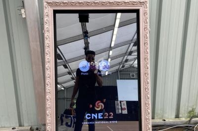 Miroir interactif avec cadre décoratif, affichant une interface numérique, installé devant un mur métallique.