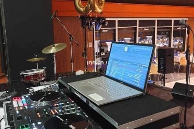 Poste de DJ avec une console Rane, un ordinateur portable et des ballons dorés ’06’ en arrière-plan.