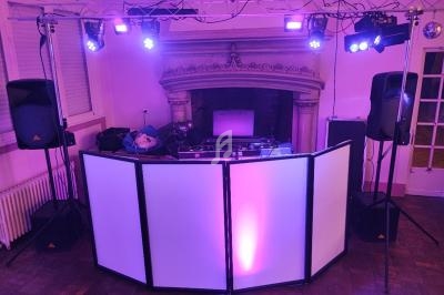 Installation de matériel de sonorisation et éclairage avec une table de mixage devant une cheminée dans une salle.